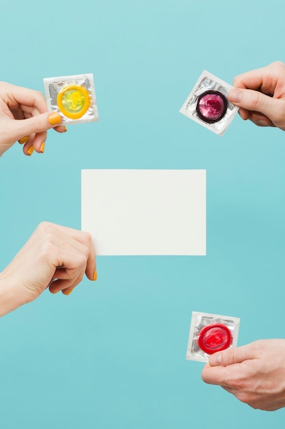 Foto gratuita personas con diferentes condones y una tarjeta vacía