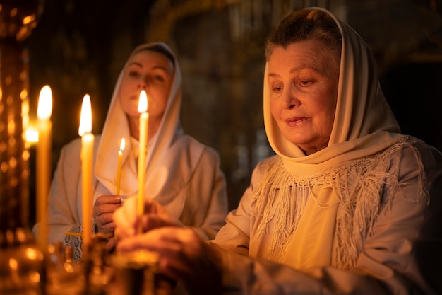 Personas encendiendo velas en la iglesia en celebración de la pascua griega