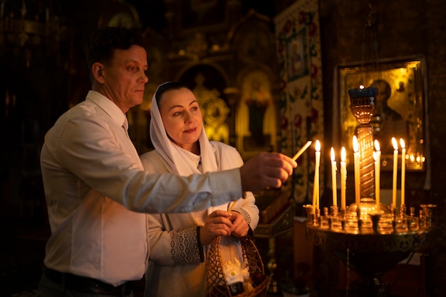 Personas encendiendo velas en la iglesia en celebración de la pascua griega