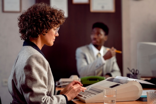 Personas de estilo antiguo que trabajan en una oficina con computadoras