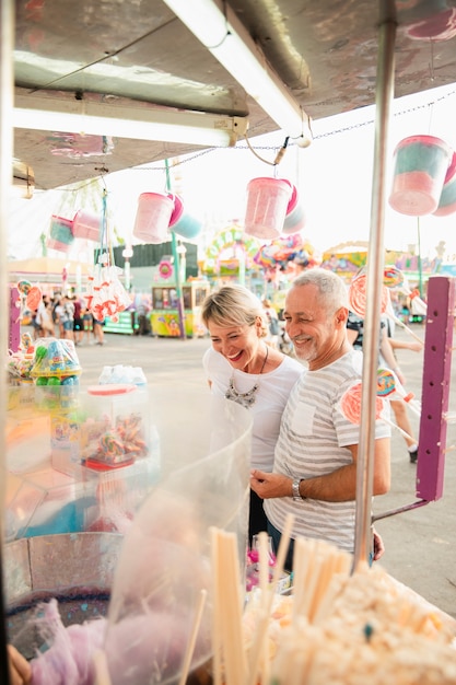 Foto gratuita personas felices de alto ángulo en el stand de dulces