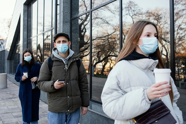 Personas en fila con máscaras.