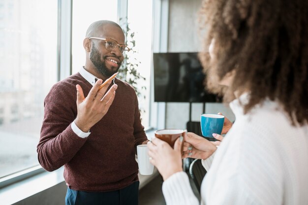 Personas hablando entre sí tomando un café durante una reunión