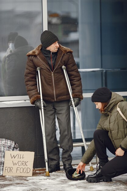 Personas sin hogar en una ciudad de invierno. Hombre pidiendo comida.