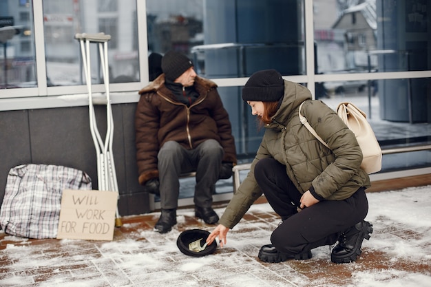 Personas sin hogar en una ciudad de invierno. Hombre pidiendo comida.