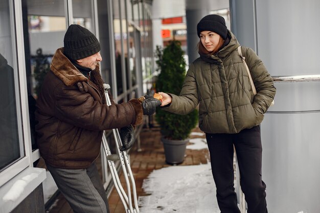 Personas sin hogar en una ciudad de invierno. Hombre pidiendo comida.
