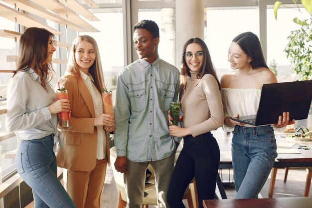 Personas internacionales de pie en un café y bebiendo un cóctel.