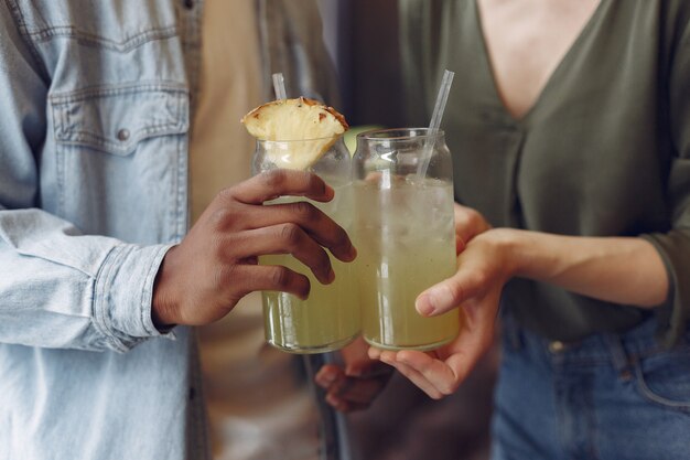 Personas internacionales de pie en un café y bebiendo un cóctel.