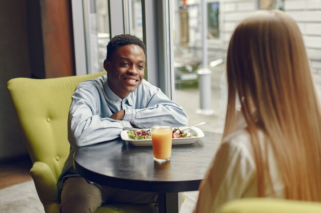 Personas internacionales de pie en un café y bebiendo un jugo