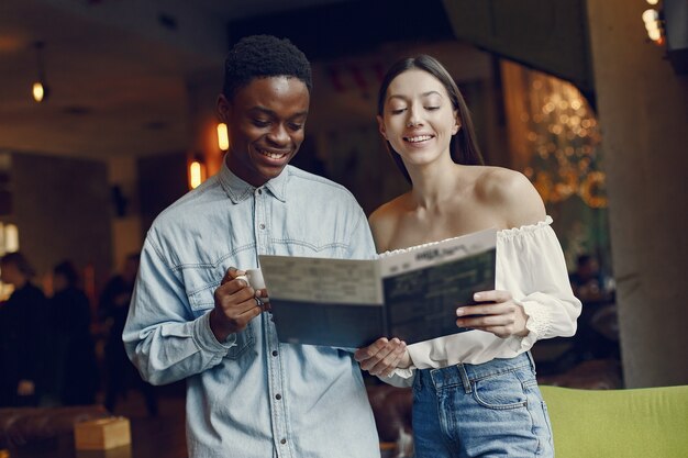 Personas internacionales de pie en una cafetería y tomando un café