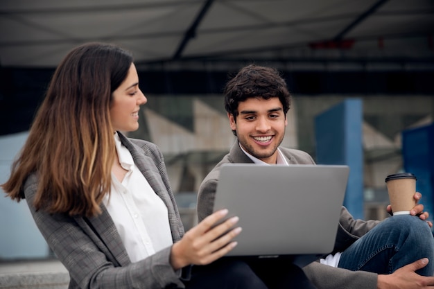 Foto gratuita personas con laptop al aire libre tiro medio