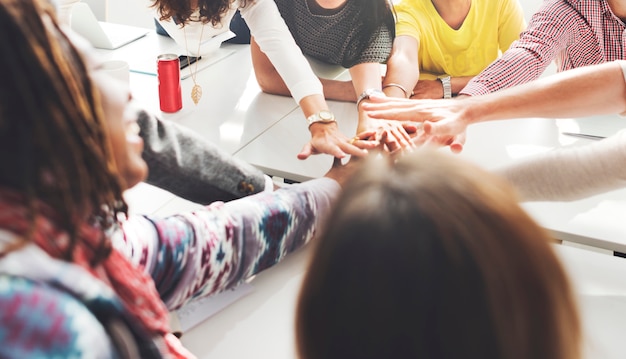 Personas con las manos unidas como equipo.