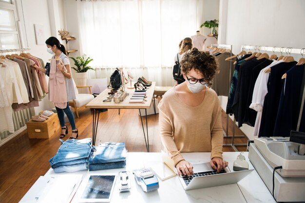 Personas con máscara en la tienda de ropa de compras en la nueva normalidad