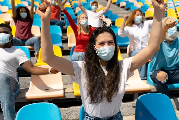 Foto gratuita personas con máscaras médicas mirando un juego.