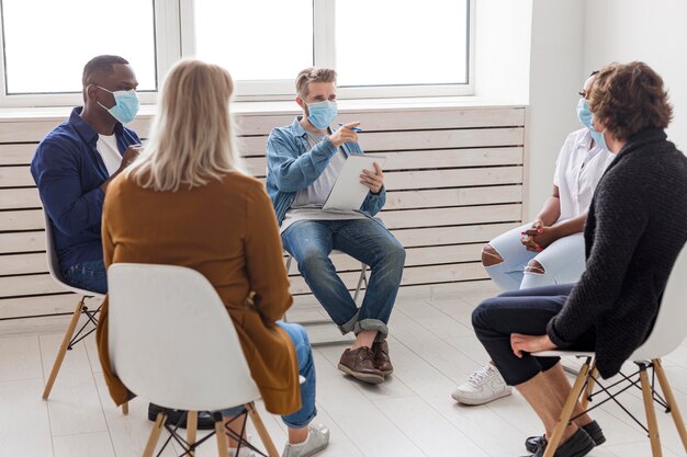 Personas con máscaras médicas en la reunión.