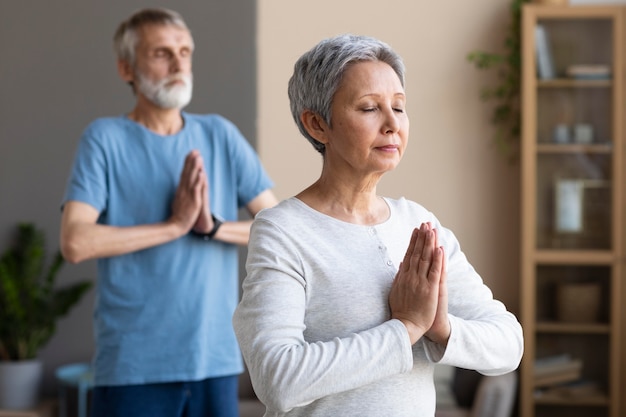 Personas mayores activas haciendo yoga en casa