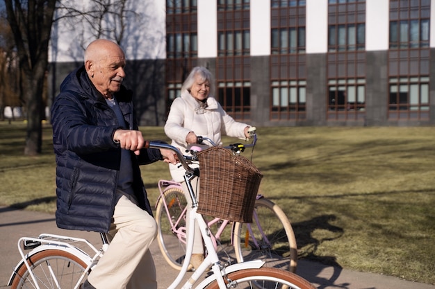 Foto gratuita personas mayores con bicicletas en vista lateral del parque