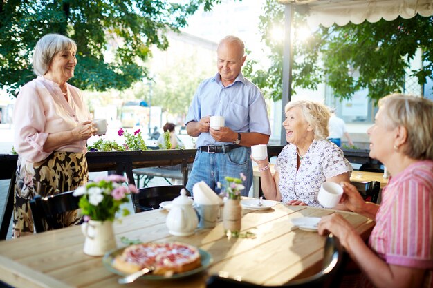 Personas mayores celebrando vacaciones en café