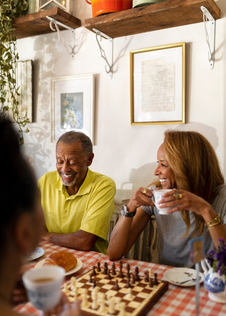 Personas mayores sonrientes bebiendo té en la mesa