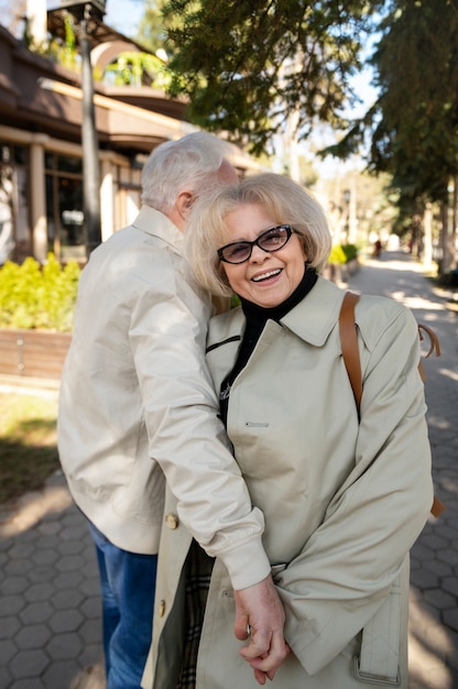 Personas mayores sonrientes de tiro medio tomados de la mano