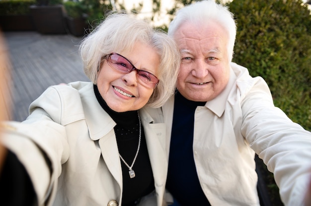 Foto gratuita personas mayores sonrientes de tiro medio tomando selfie