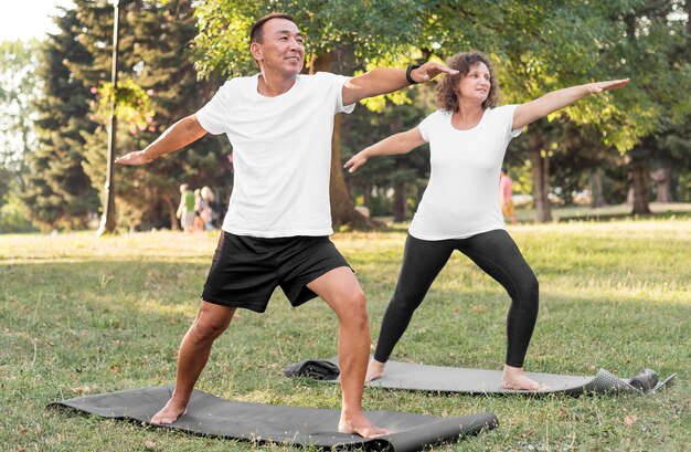 Personas mayores de tiro completo ejercicio en colchonetas de yoga