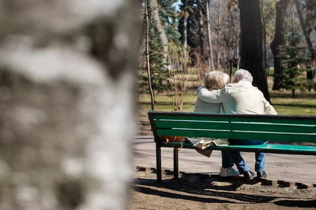 Personas mayores de tiro completo sentadas en un banco