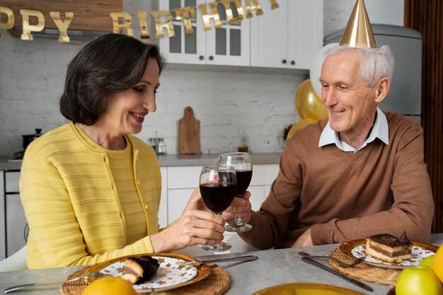 Personas mayores de tiro medio celebrando cumpleaños
