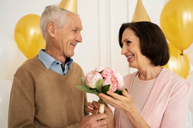 Personas mayores de tiro medio con flores