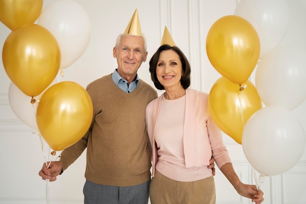 Personas mayores de tiro medio con globos