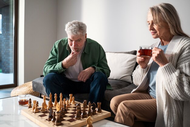 Personas mayores de tiro medio jugando al ajedrez