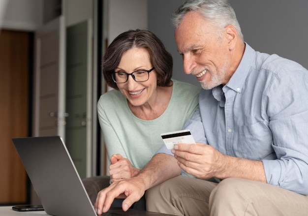 Personas mayores de tiro medio con laptop