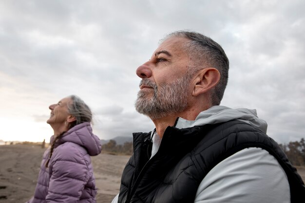 Personas mayores de tiro medio meditando al aire libre