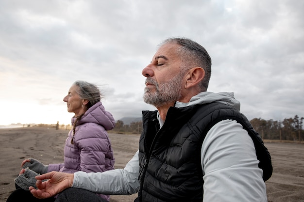 Foto gratuita personas mayores de tiro medio meditando