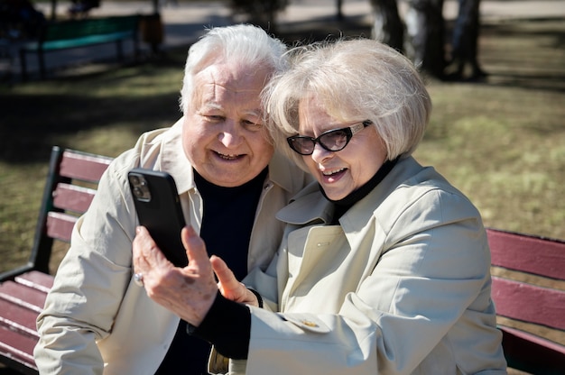 Personas mayores de tiro medio tomando selfie
