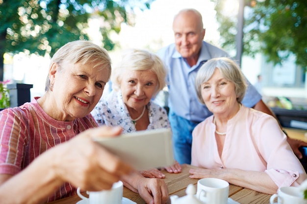 Personas mayores tomando selfie con smartphone