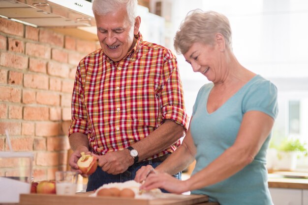 Personas mayores trabajando juntos en tarta de manzana casera