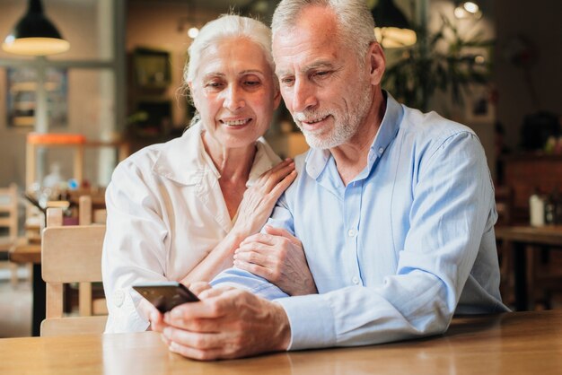 Personas de mediana edad con teléfono inteligente.