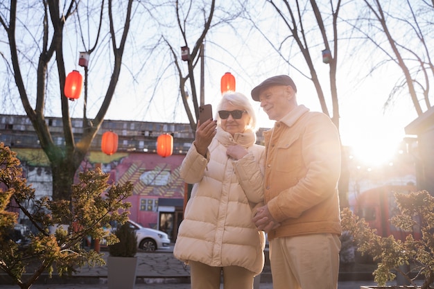 Foto gratuita personas de mediana edad con teléfono inteligente.