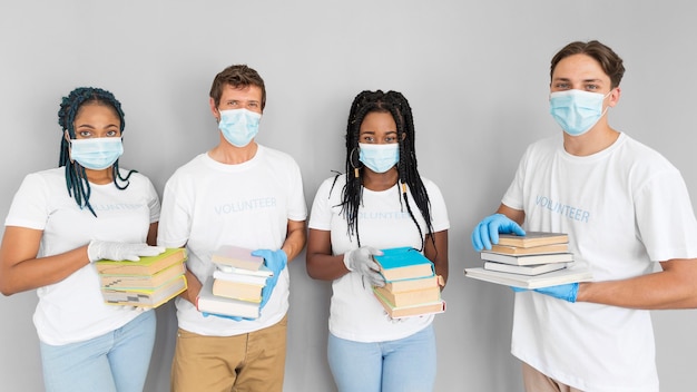 Personas con un montón de libros para donarlos.