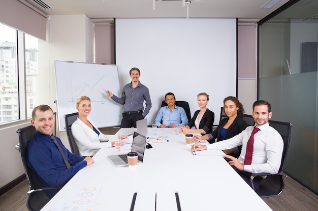 Personas de negocios posando sonrientes en una sala de reuniones