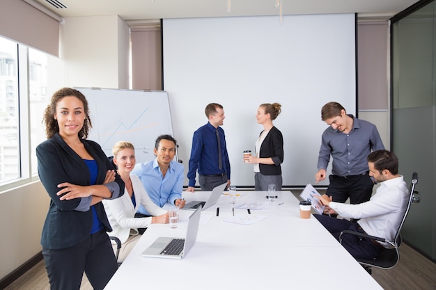 Personas de negocios posando sonrientes en una sala de reuniones