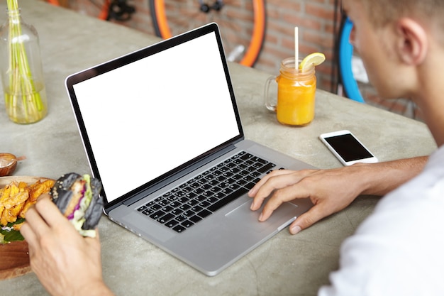 Personas, ocio y tecnología. Estudiante rubia usando wi-fi en la computadora portátil