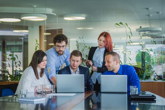 Personas con ordenadores portátiles en la oficina