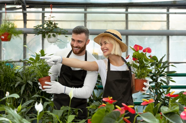 Foto gratuita personas de plano medio cuidando plantas.