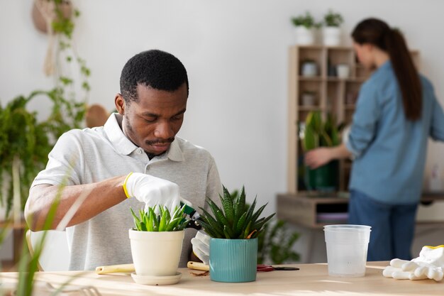 Personas de plano medio cuidando plantas.