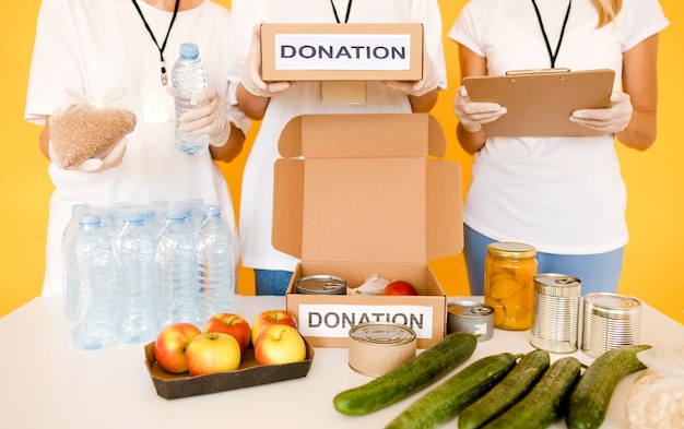 Personas preparando cajas de donaciones con provisiones para el día de la comida
