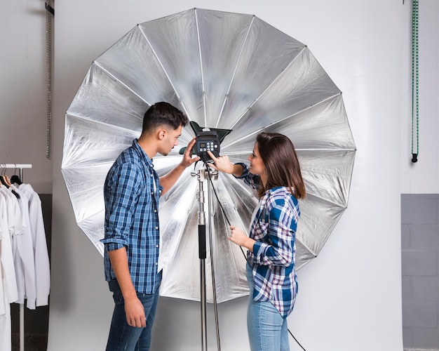 Personas preparando el equipo para una sesión de fotos.