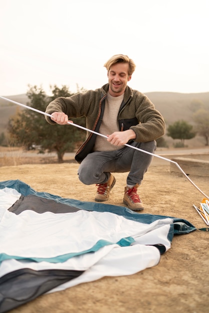 Foto gratuita personas preparando su carpa para acampar en invierno.