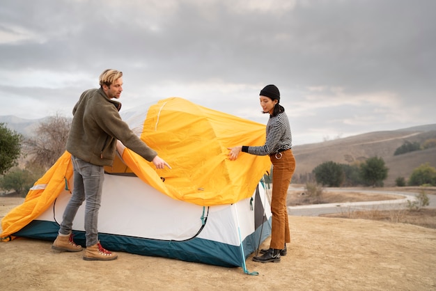 Personas preparando su carpa para acampar en invierno.